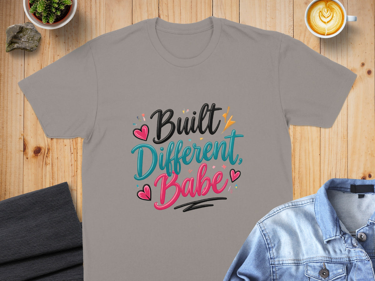 Gray t-shirt with "Built Different, Babe" text and graphic design.