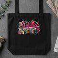 Black tote bag with floral design and text "Teachers make the world brighter."